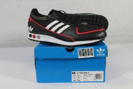 A pair of boxed as new Adidas LA Trainer II Trainers in CBLACK/FTTWWHT/BETSCA, Size UK 12.5.