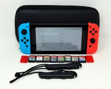 A pre-owned Nintendo Switch (HAC-001) Hand-Held Game Console in with eight assorted game cards in ca