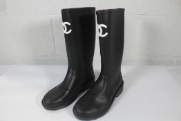 A pair of women's pre-owned Chanel Rubber Boots - Black (EU 39, some heavy scratches).