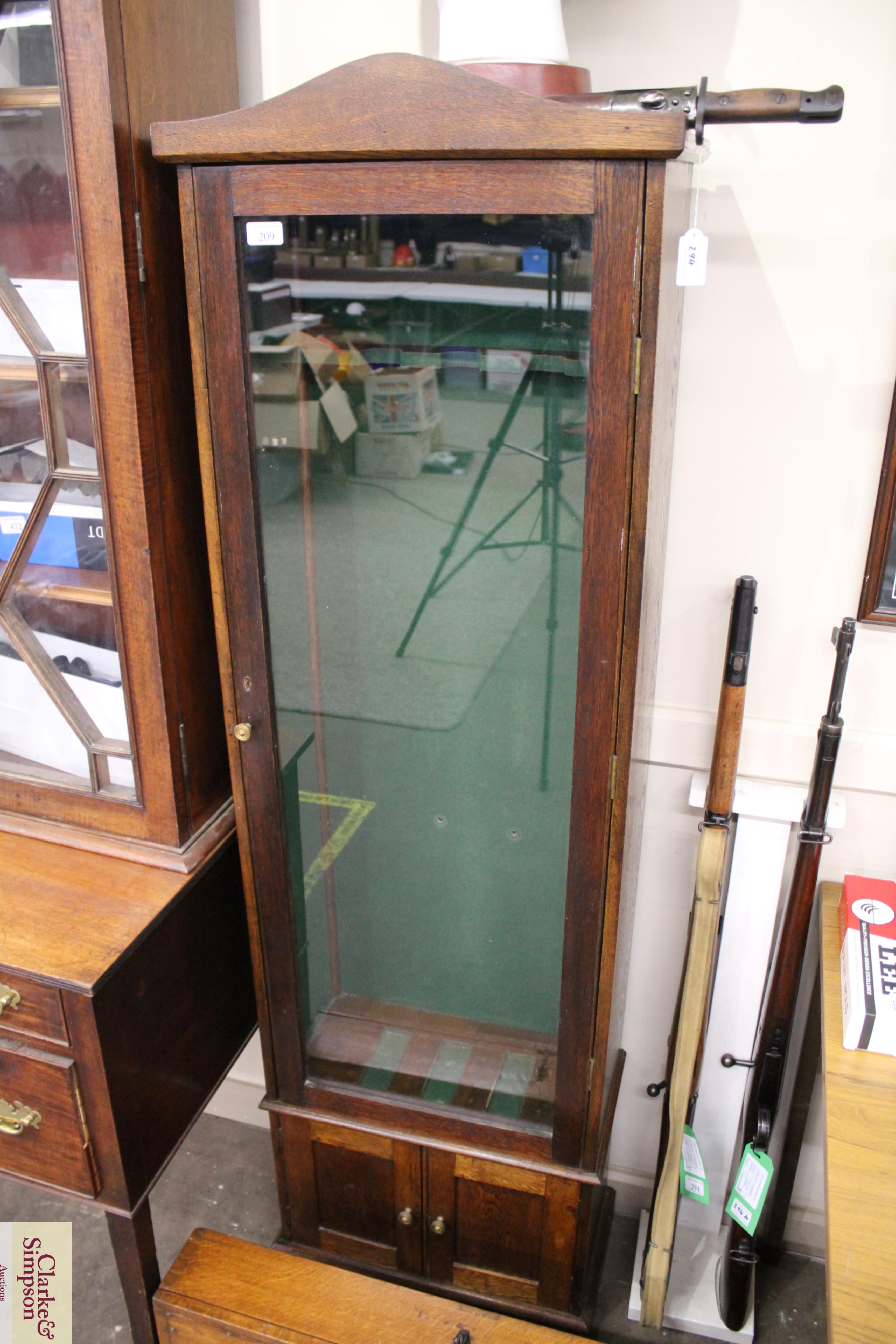 A fine three gun oak display cabinet with cupboard