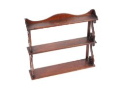 An early 19th Century mahogany three tier waterfall hanging set of bookshelves, 64cm wide x 54cm