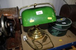 A brass desk lamp with green glass shade