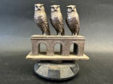 A rare and unusual car accessory mascot depicting three owls evenly placed upon a bridge of three