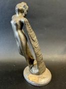 A car accessory mascot in the form of a nude female leaning backwards, with trailing wings for arms,