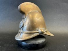 A brass car mascot in the form of a fireman's helmet, metal display base mounted, approx. 4