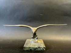 A car mascot depicting a bird in flight, marble base, stamped LL (Lejeune) to base approx. 3 1/2
