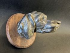 A car mascot in the form of a hound's head, wooden display base mounted, approx. 3 3/4