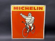 A Michelin pictorial tin advertising sign depicting Mr Bibendum sat upon a bicycle, 17 x 17 1/2