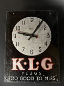 A Smiths Sectric tin fronted wall clock, with advertising for KLG Plugs, 10 1/2 x 14