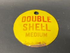 A small circular enamel brand tag for Double Shell Medium, 2 3/4