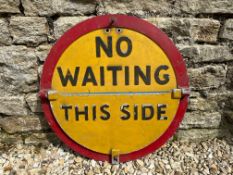 A circular 'No Waiting' aluminium road sign with semi-circular hinged section revealing different