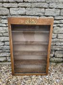 A Desmo wooden front-opening display cabinet with celluloid badge inside of door, 23 3/4 x 36