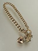 A 9ct gold kerb link chain bracelet with pig and heart charms and ring fastening, (D x 8 cm). 15.5g