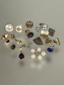 A collection of odd yellow and white metal earrings including a mabe pearl stud earring, cultured