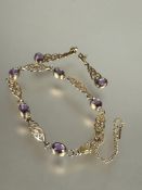 A 9ct gold Celtic knot line style bracelet set five oval amethysts in rub over setting with safety