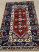EASTERN WOOLLEN RUG - blue ground with red central diamonds motifs, 185 x 118cms
