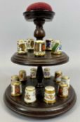 ROYAL CROWN DERBY - a collection of 12 thimbles on a circular two-tier stand with central pin