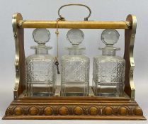 EDWARDIAN OAK TANTALUS - with EPNS mounts and loop handle containing three square cut glass