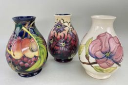 THREE MODERN WILLIAM MOORCROFT TUBELINE DECORATED OVOID VASES, to include magnolia on a white