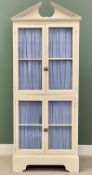 TALL PAINTED CUPBOARD - with broken architectural pediment over four fabric backed glazed doors,