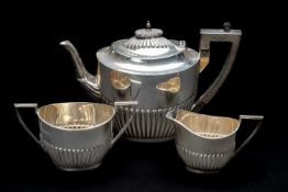 EDWARD VII SILVER THREE-PIECE BACHELOR'S TEA SET, Walker & Hall, Sheffield 1907, half-fluted oval