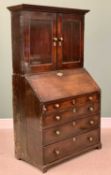 GEORGIAN OAK BUREAU CUPBOARD having a two door upper section with interior shelves, pigeonholes