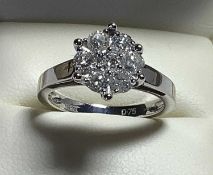 18KT WHITE GOLD SEVEN STONE DIAMOND CLUSTER RING, of flowerhead design, the round cut stones