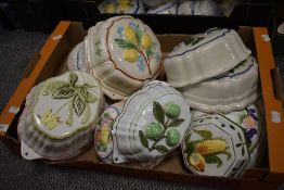 A box of decorative ceramic food moulds, having raised designs of fruit and vegatables.