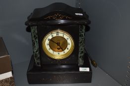 A Victorian marble mantle clock having green veined columns to sides, etched detailing to front