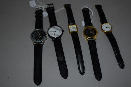 Five mens watches all having black straps.