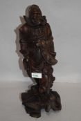 An early 20th century Japanese wood carving of an official figure or samurai, having a damaged