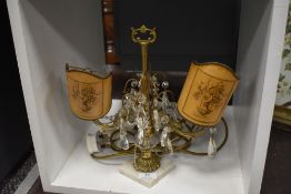 A vintage table lamp having lustre drops and twin candelabra style light fittings with paper