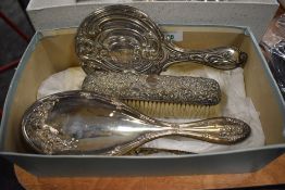 A group of three silver mounted dressing table wares, comprising hand mirror, hair brush, clothes