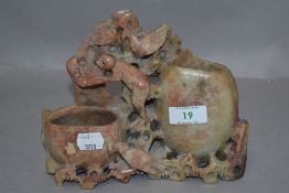 A 20th century carved and etched natural stone vase depicting flowers and animals, having dual
