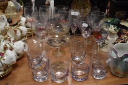 A mixed lot of colourful glasses, including wine glasses, tumblers and champagne.