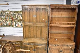 A suit of Old Charm oak furniture including a secretaire cupboard unit, a book shelf with under
