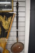 An antique bed warming pan