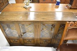 A priory style low book case with bouble cupboard space and leaded light glazed doors