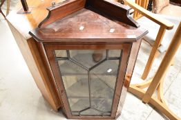 An Edwardian mahogany corner wall cabinet