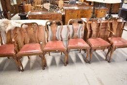 An early 20th Century walnut dining table and set of six vase back dining chairs with red leather