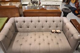 A modern Tetrad sofa with grey button back upholstery