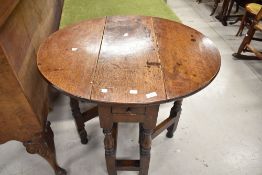 An early 20th century small sized oak framed gate leg table with drawer 74cm tall