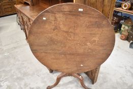 A Victorian tilt top tea or loo table with tripod base and plain mahogany top