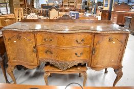 An early 20th century side board base having burr Walnut veneer and carved decoration of cabriole