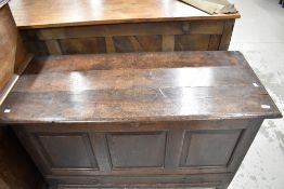 A period oak kist having three panels and drawer base