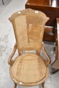 A late Victorian low nursing style rocking chair having a restored bergere woven back and seat