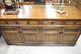 An Old Charm oak side board with bouble cupboard base and four under drawers