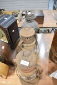 A Victorian pewter oil lamp base and two storm lanterns