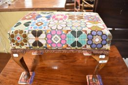 A vintage footstool having woolwork top