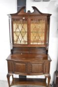 A fine early 20th Century mahogany display cabinet having broken pediment, blind fretwork frieze